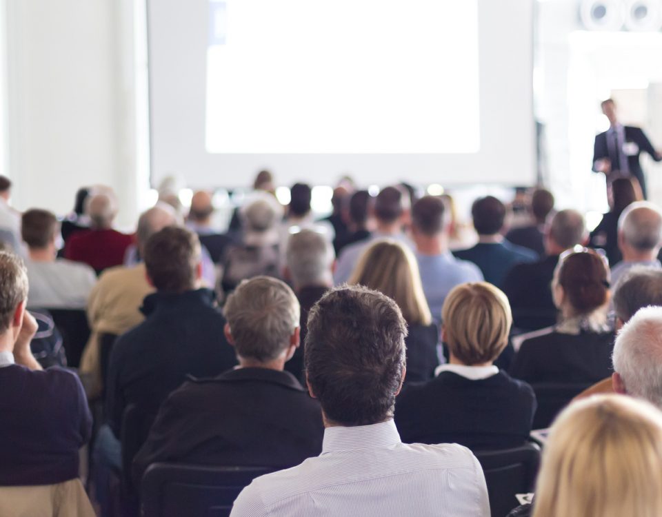 Speaker Giving a Talk at Business Meeting. Audience in the conference hall. Business and Entrepreneurship. Panoramic composition suitable for banners.